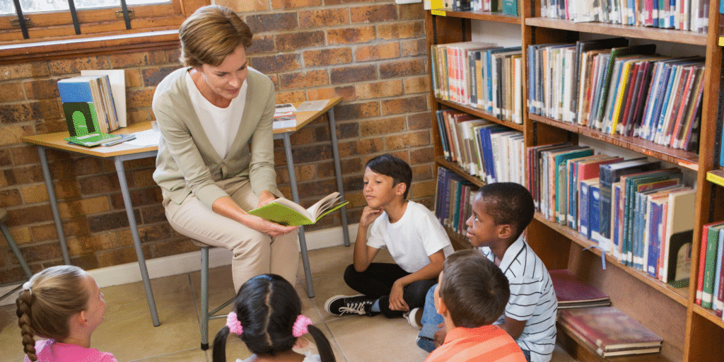 a teaching assistant reads to a class of young children