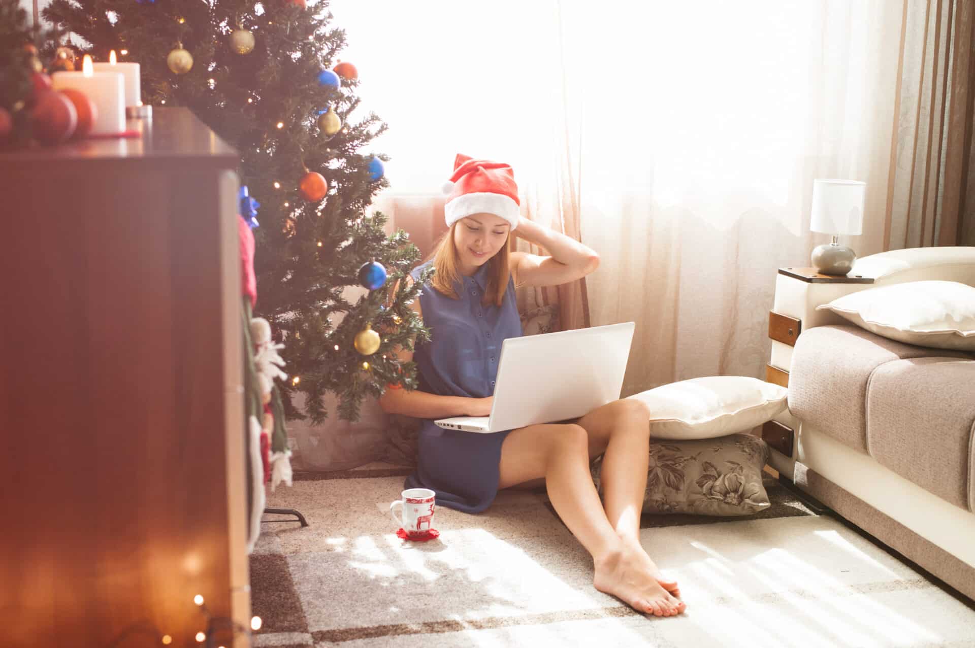 a woman studies at home next to a christmas tree