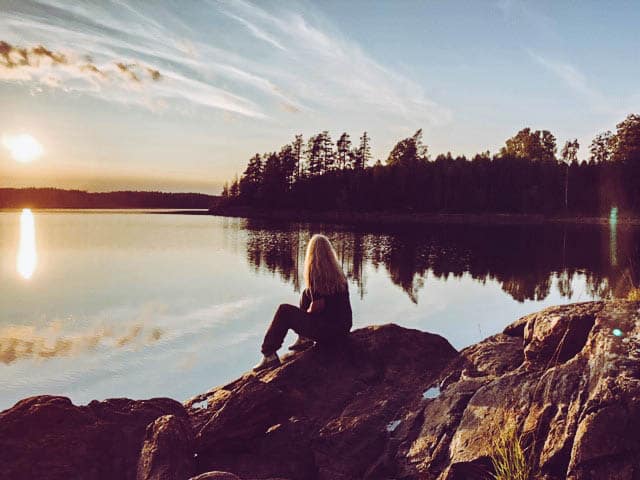 Suzanne sits on the banks of a lake in Norway. Her I can I will story is to get back here one day.