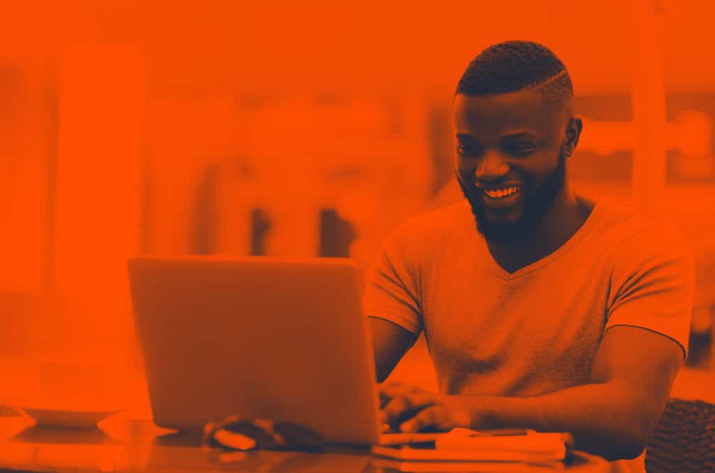 Man smiling studying on laptop
