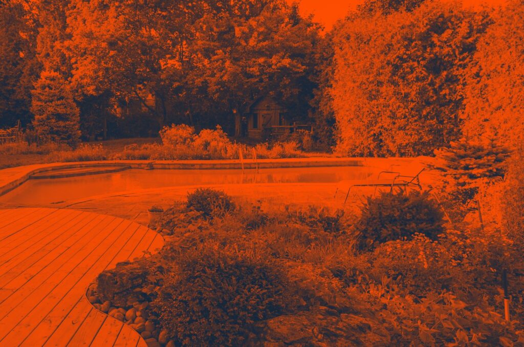 A pretty garden with a deck and a large pond