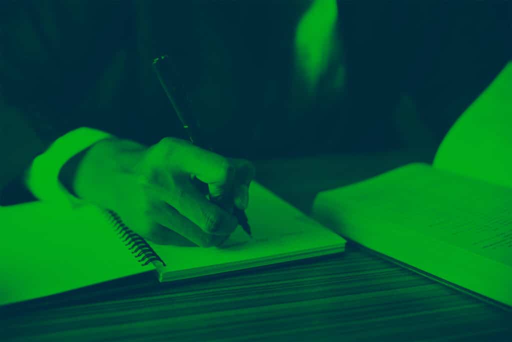 person making notes at a desk