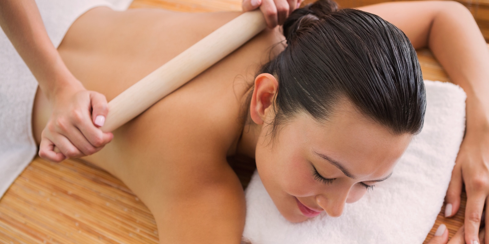 An image of a woman getting a bamboo massage