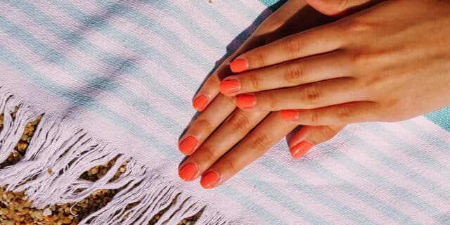 An image of two hands with orange coloured nails, showing casing fusion gel course