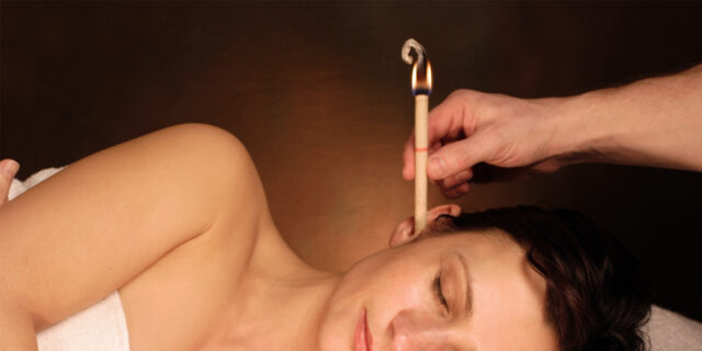 An image of a woman laying on her side with a hopi ear candle in her ear