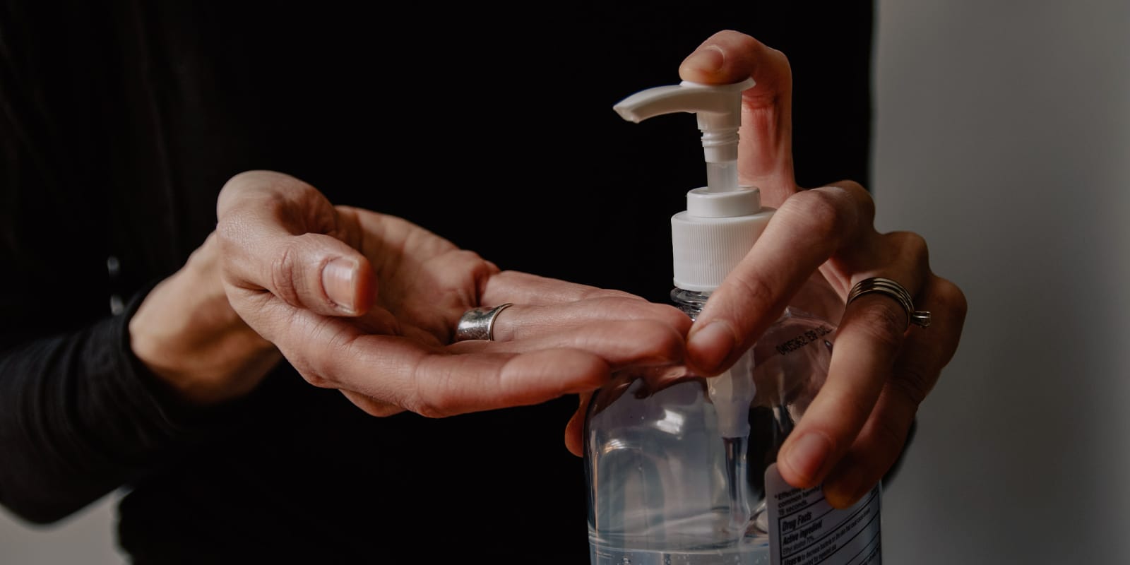An image of a woman with a sanitiser bottle in her hands