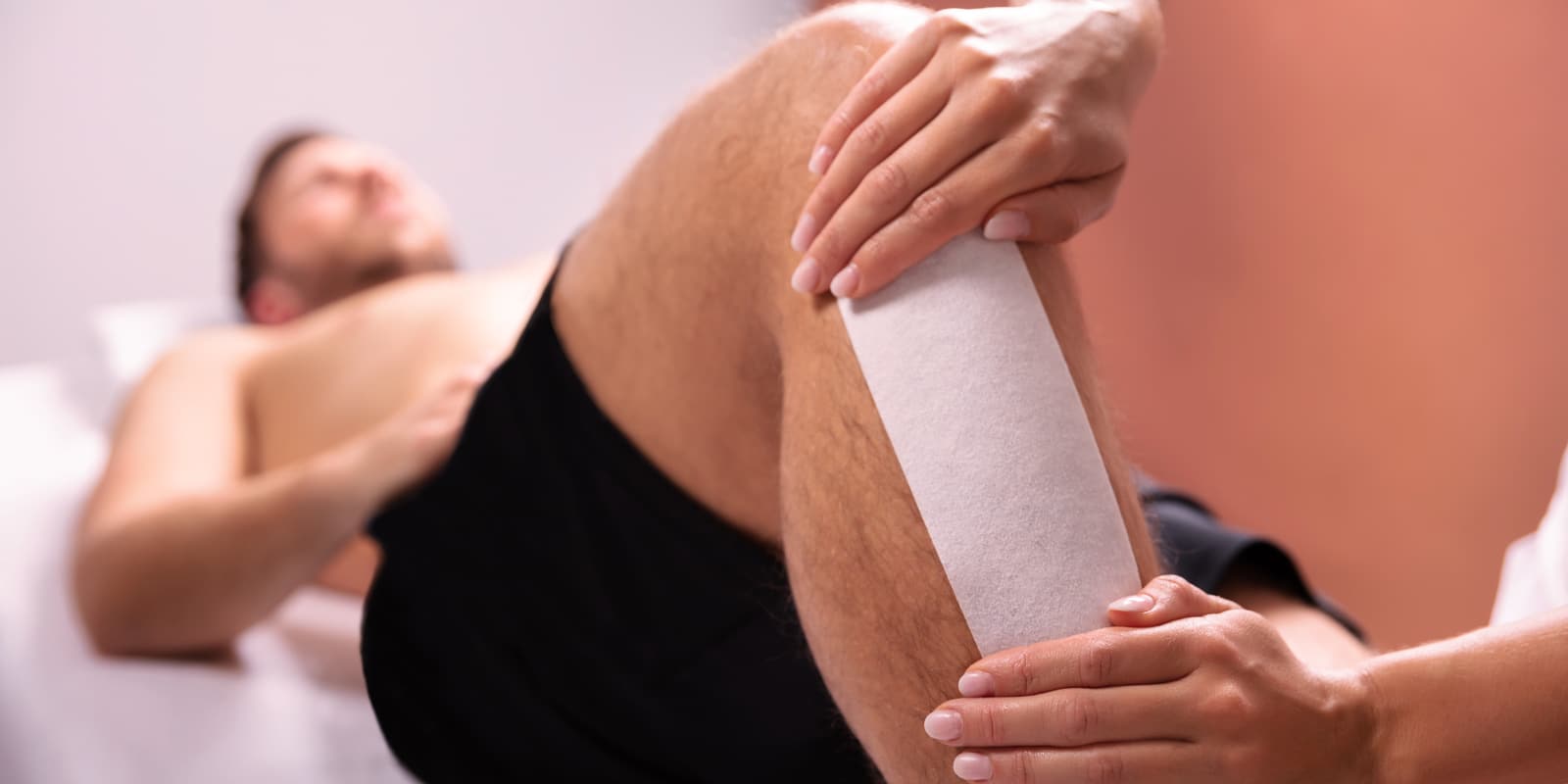 An image of a man getting his leg waxed