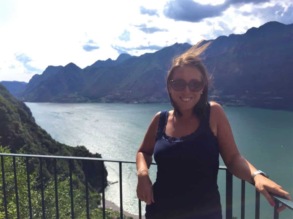 A photo of Elena on a balcony overlooking a river and mountains.