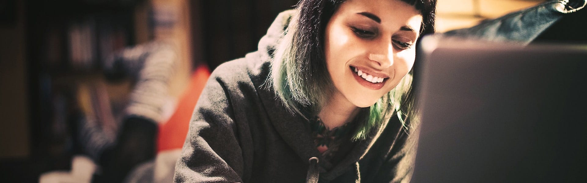 young woman with green hair on her laptop