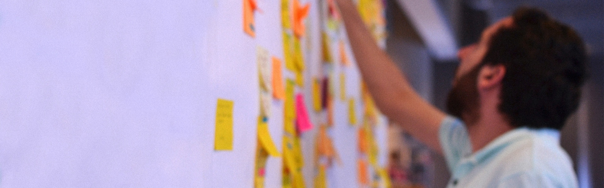 a man places post it notes on a wall