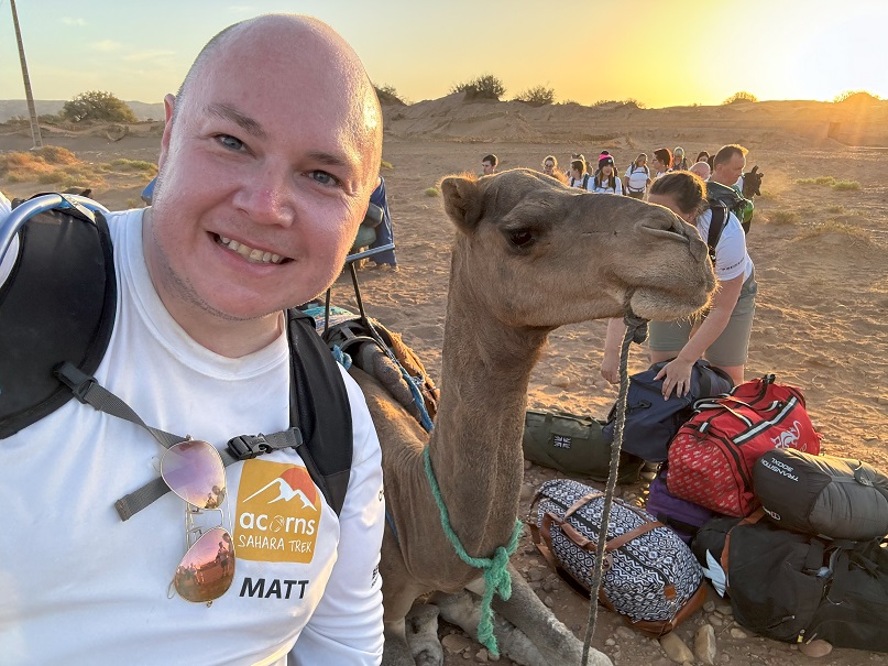 Matt Jones with a camel as part of the Acorns Sahara Trek.