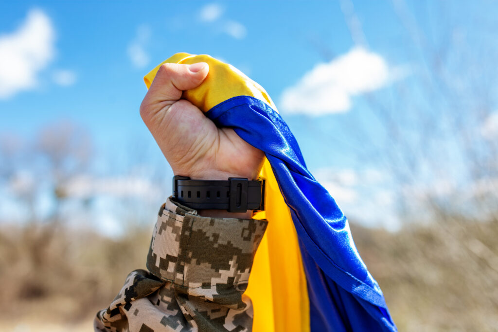 A Ukrainian soldier proudly clutching the Ukrainian flag