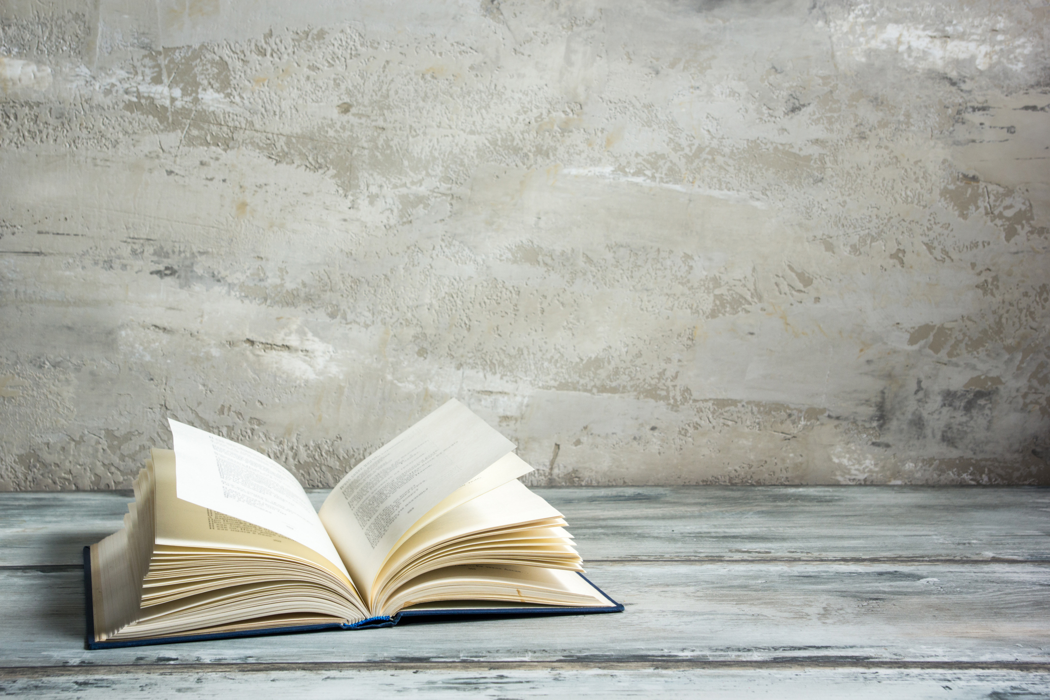 Vintage old hardback book in front of a stone-inspired background.